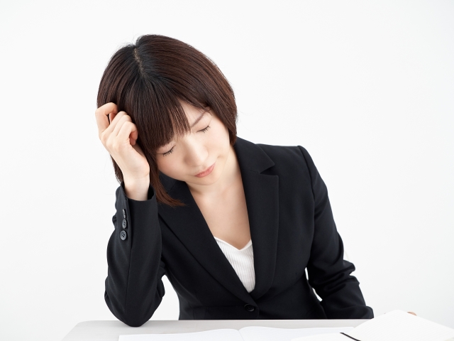 白背景で頭痛に悩む女性OL